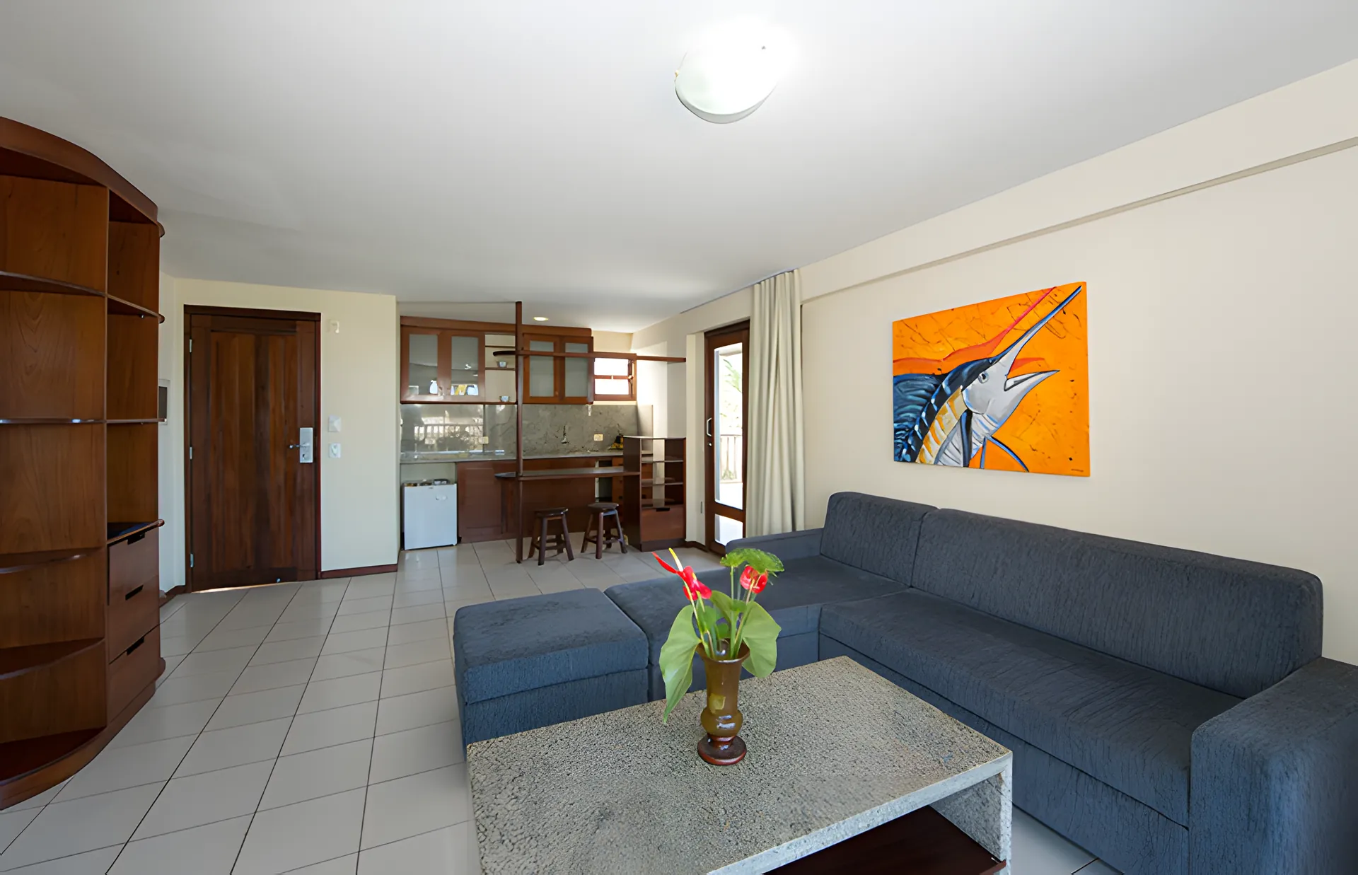 Sala com sofá e cozinha americana